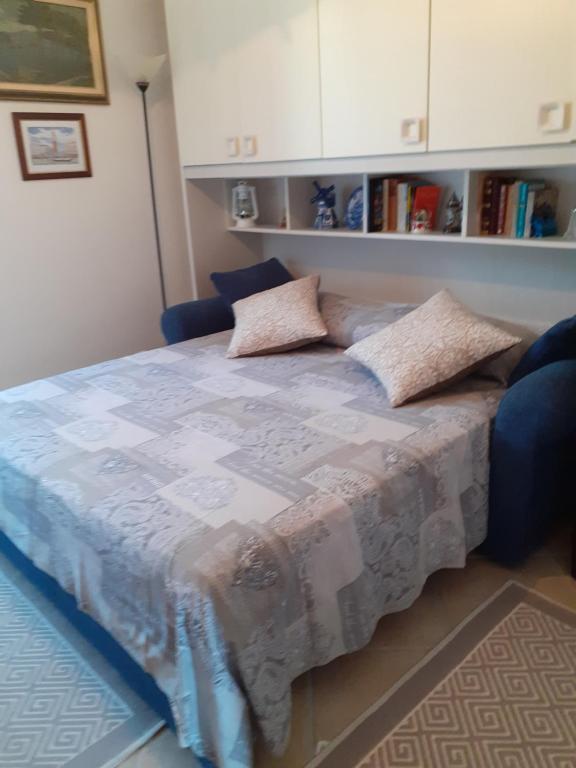 ein Schlafzimmer mit einem Bett mit einem blauen Stuhl in der Unterkunft Camera per breve periodi in Iglesias