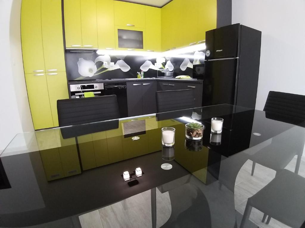 a kitchen with a table and a black refrigerator at Апартамент Трапезица in Veliko Tŭrnovo