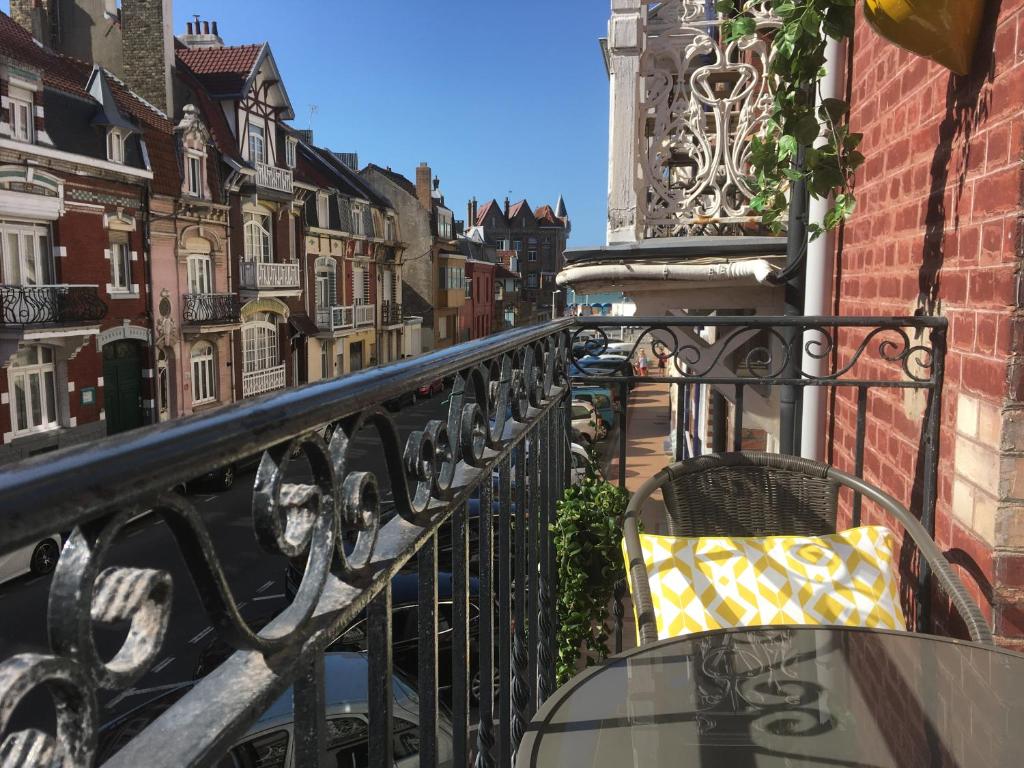 a balcony with a yellow pillow sitting on a fence at VILLA JULIETTE in Dunkerque