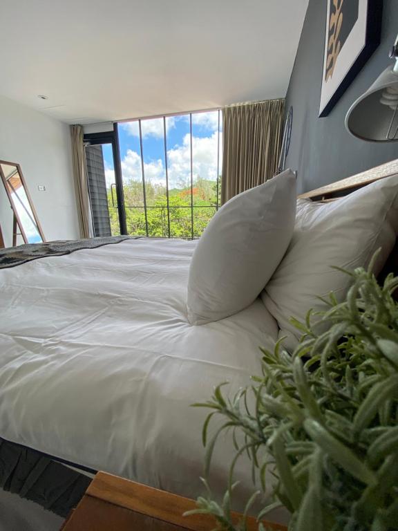 a bed with a pillow and a window in a room at Playful House in Kenting