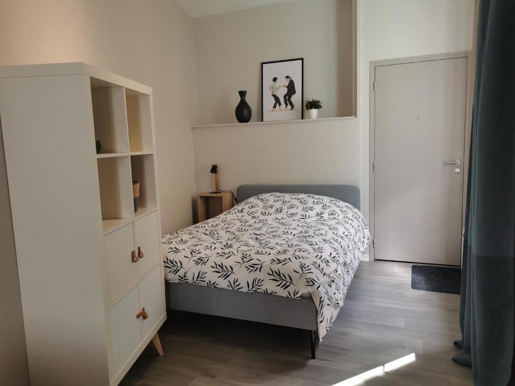 a bedroom with a bed and a dresser and a door at Suite Orphelins 2 (rdc) in Reims