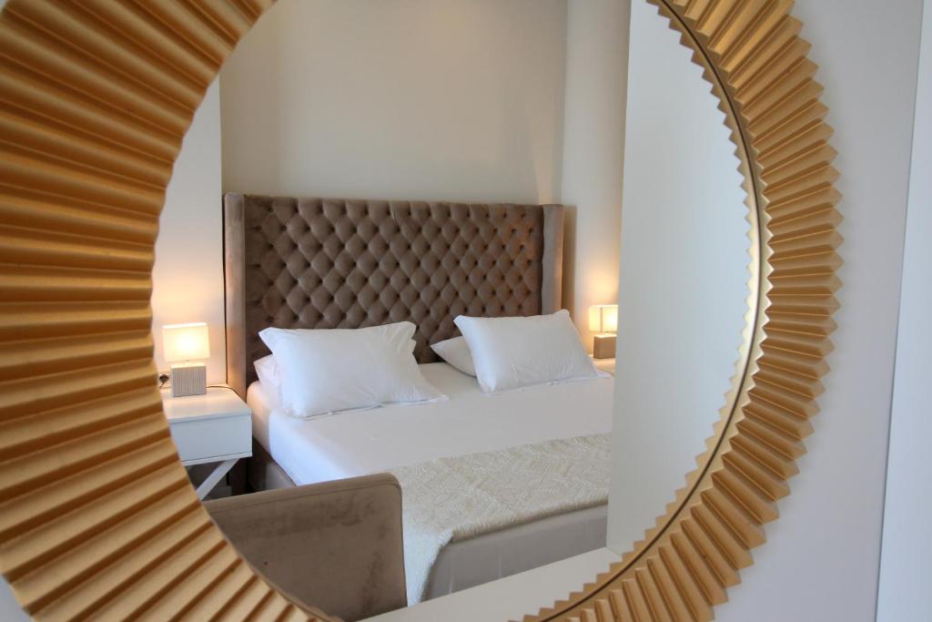 lustro odzwierciedlające sypialnię z łóżkiem w pokoju w obiekcie Hotel Sejko w Sarandzie