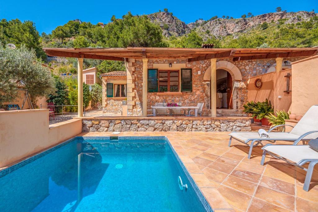 a villa with a swimming pool and a house at Ca n'aina in Cala Tuent