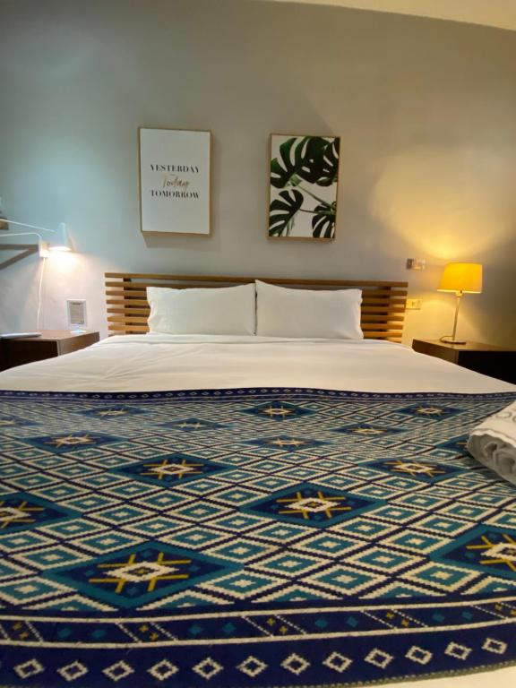a bedroom with a large bed with a blue rug at Playful House in Kenting