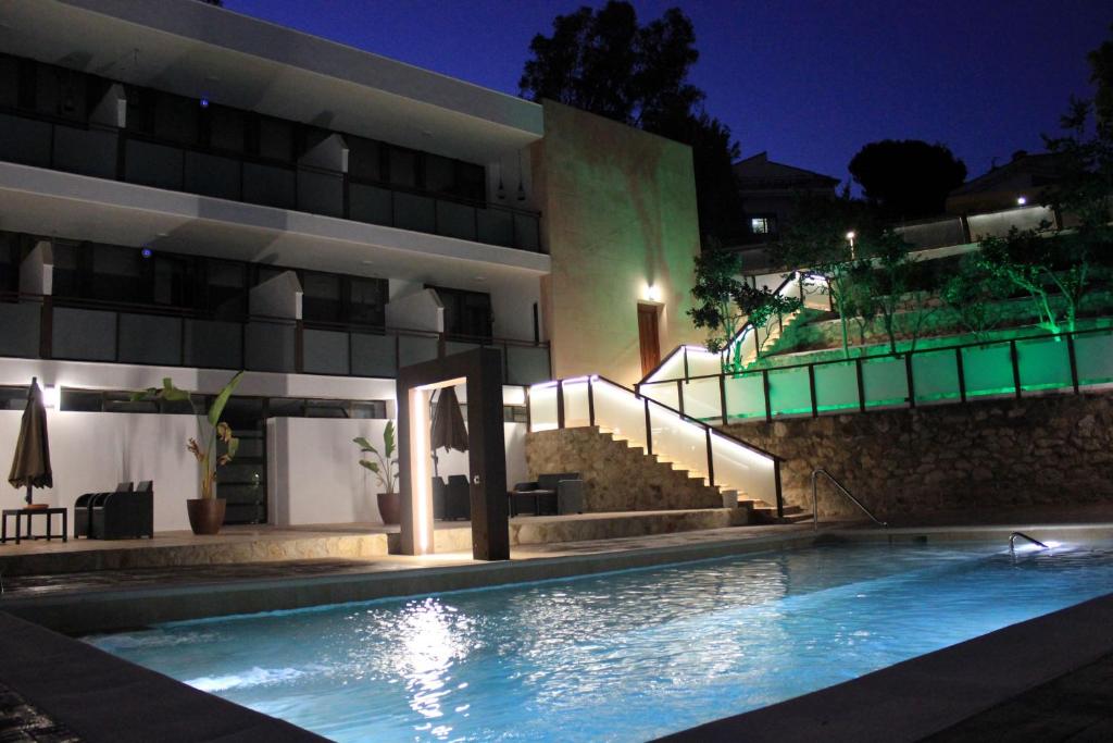 a swimming pool in front of a building at night at Apartamentos Rurales El Mirador in Córdoba