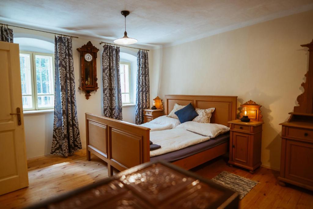 1 dormitorio con 1 cama y reloj en la pared en Apartmány Rodný dom Deža Hoffmanna, en Banská Štiavnica