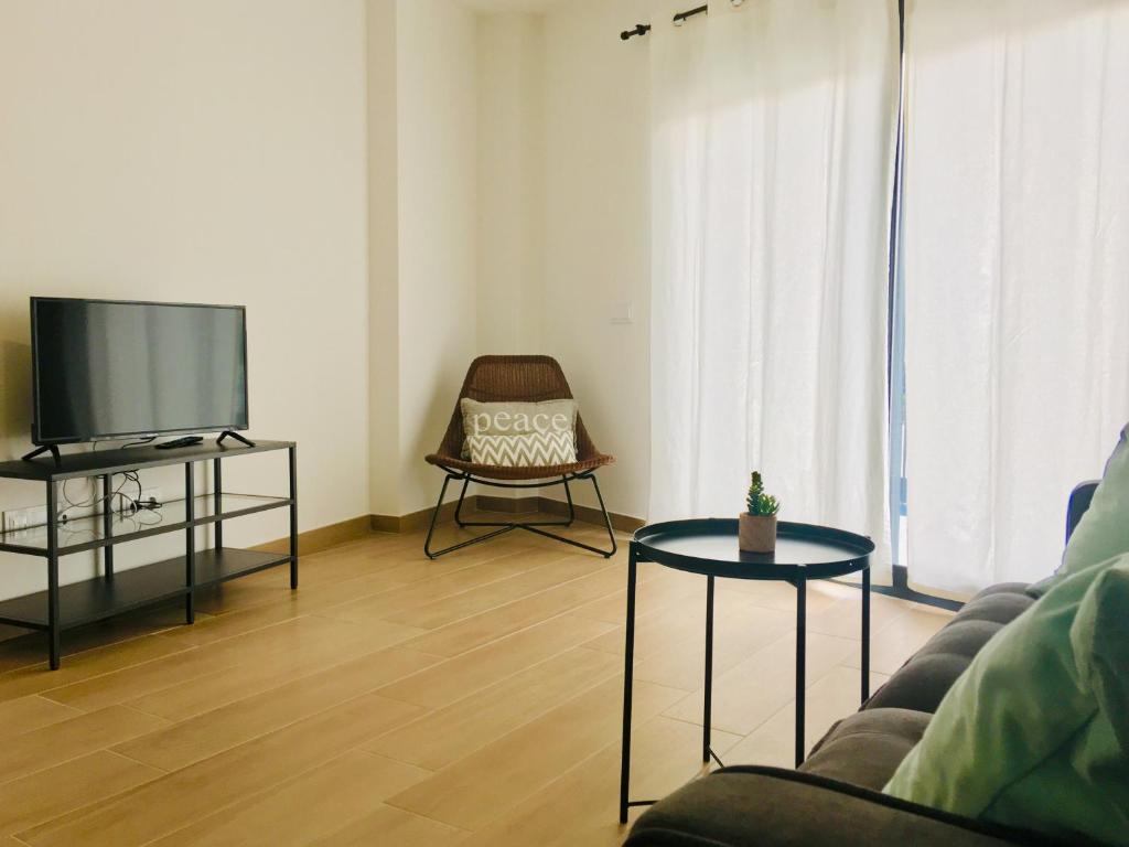a living room with a couch and a tv at Aiguaneu El Celler in Blanes