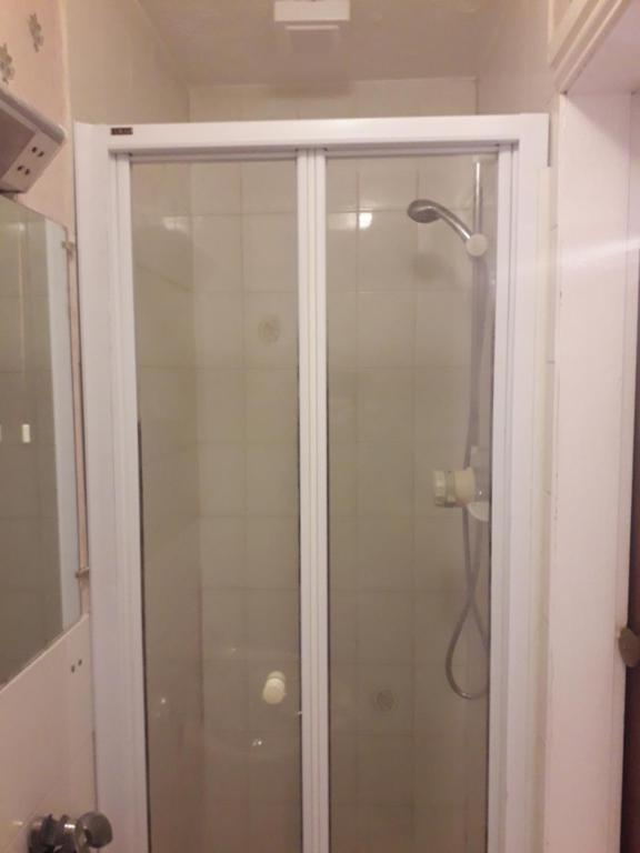 een douche met een glazen deur in een badkamer bij Witton house in Blackpool