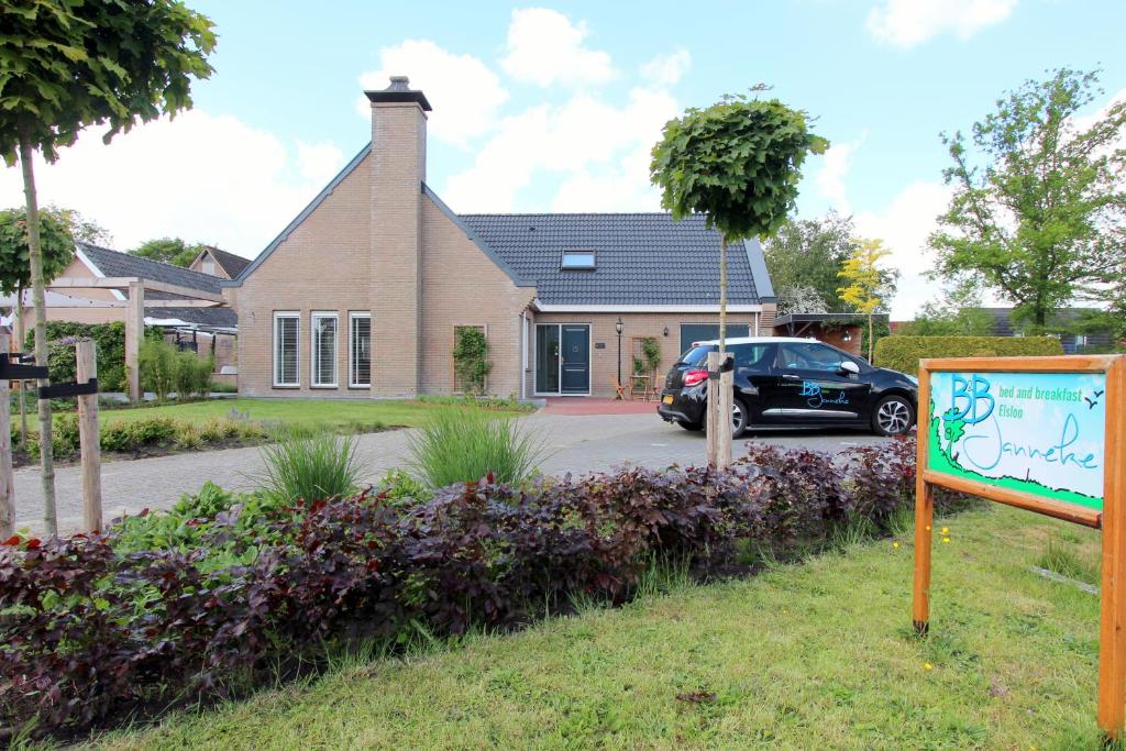 a sign in front of a house with a car at B & B Janneke Elsloo Friesland in Elsloo