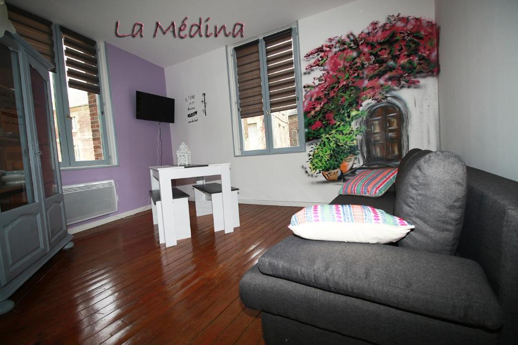 a living room with a couch and a table at LA MEDINA in La Fère