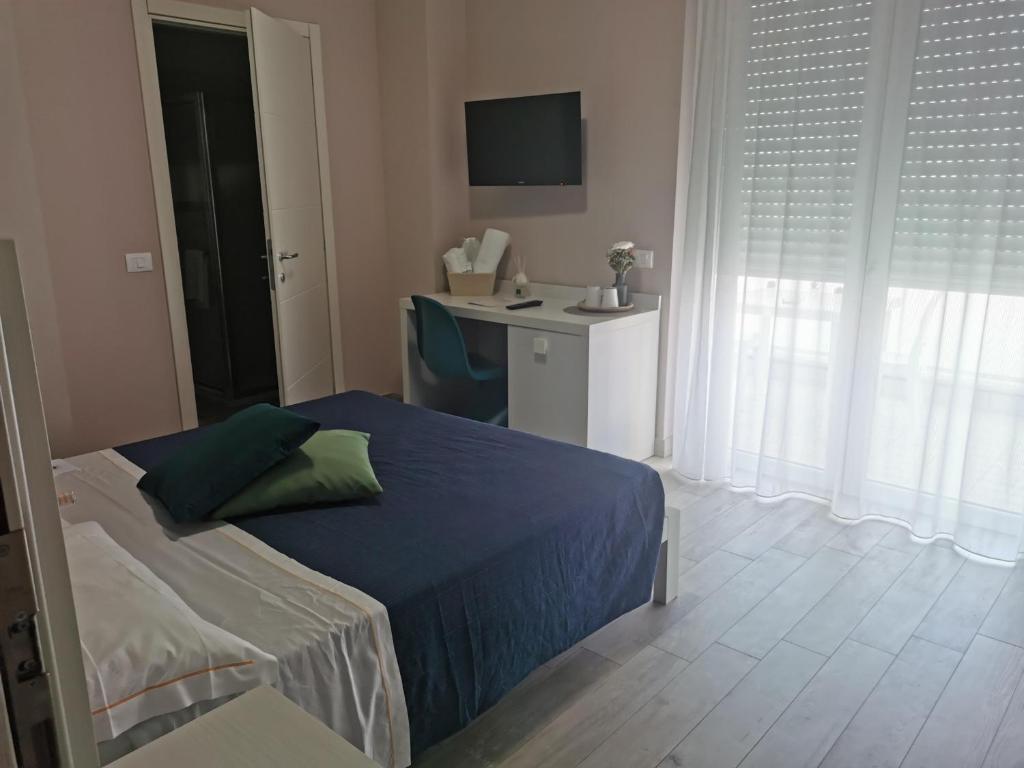 a bedroom with a bed and a desk with a monitor at Elite Boutique Hotel in Roseto degli Abruzzi