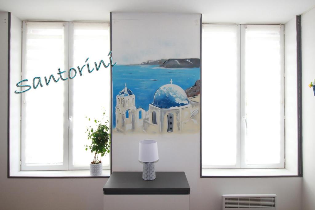a room with two windows and a painting on the wall at Santorini in La Fère