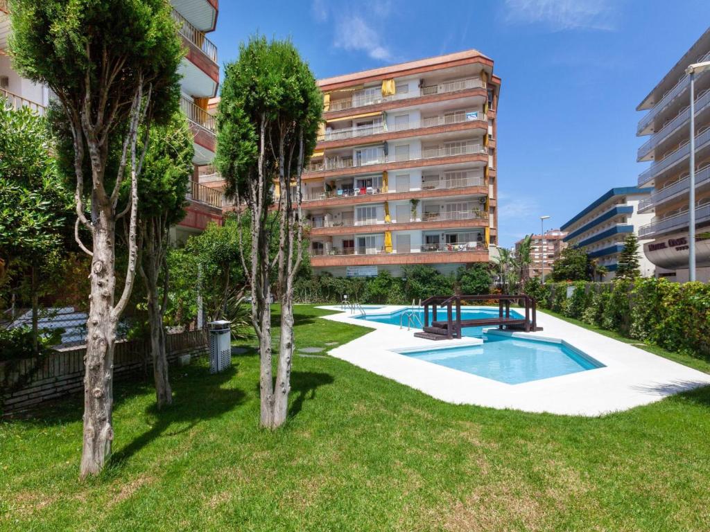 an apartment with a yard with a swimming pool and trees at Apartment Las Americas by Interhome in Lloret de Mar