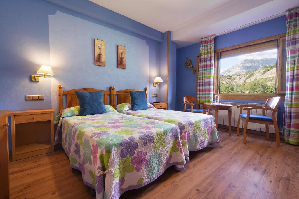 Una habitación de hotel con dos camas y una ventana. en Hotel Cinca, en Escalona