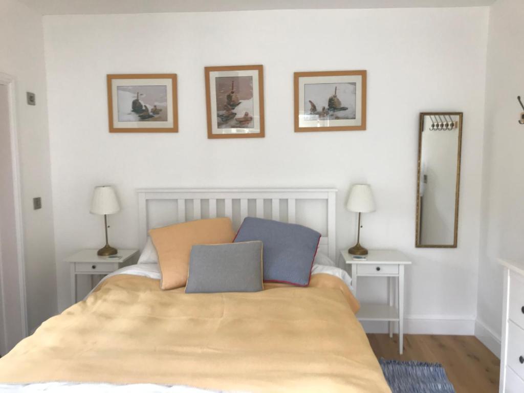 a bedroom with a bed with two tables and two mirrors at The Retreat in Sheringham