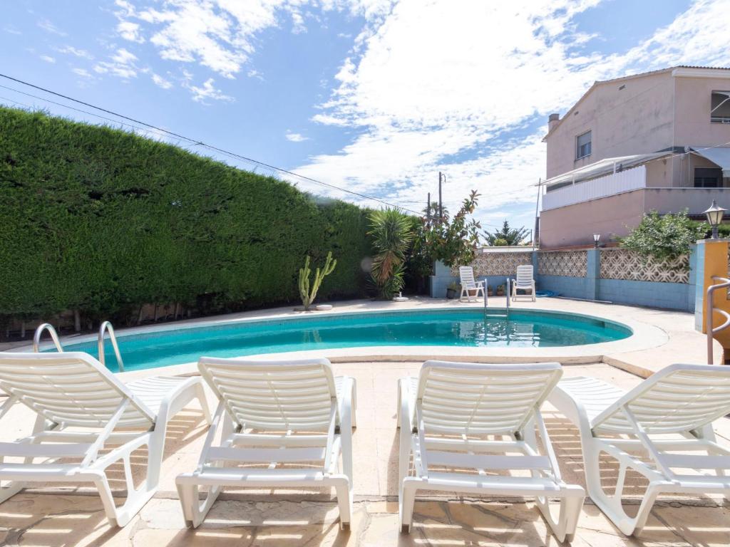 a group of chairs and a swimming pool at Holiday Home Lleida-1 by Interhome in Torredembarra