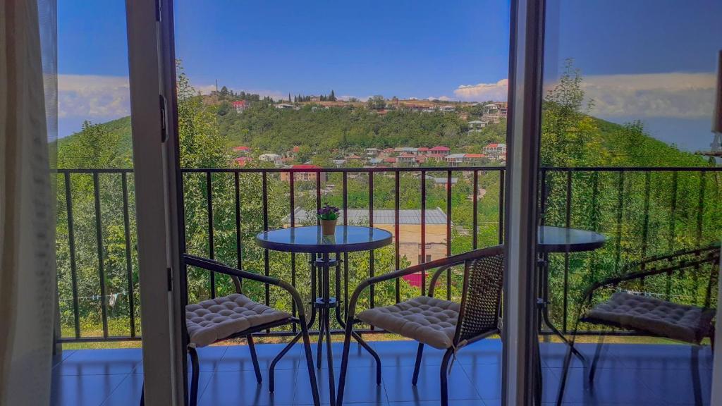 einen Balkon mit einem Tisch und 2 Stühlen sowie Aussicht in der Unterkunft Guest House Maradona in Sighnaghi