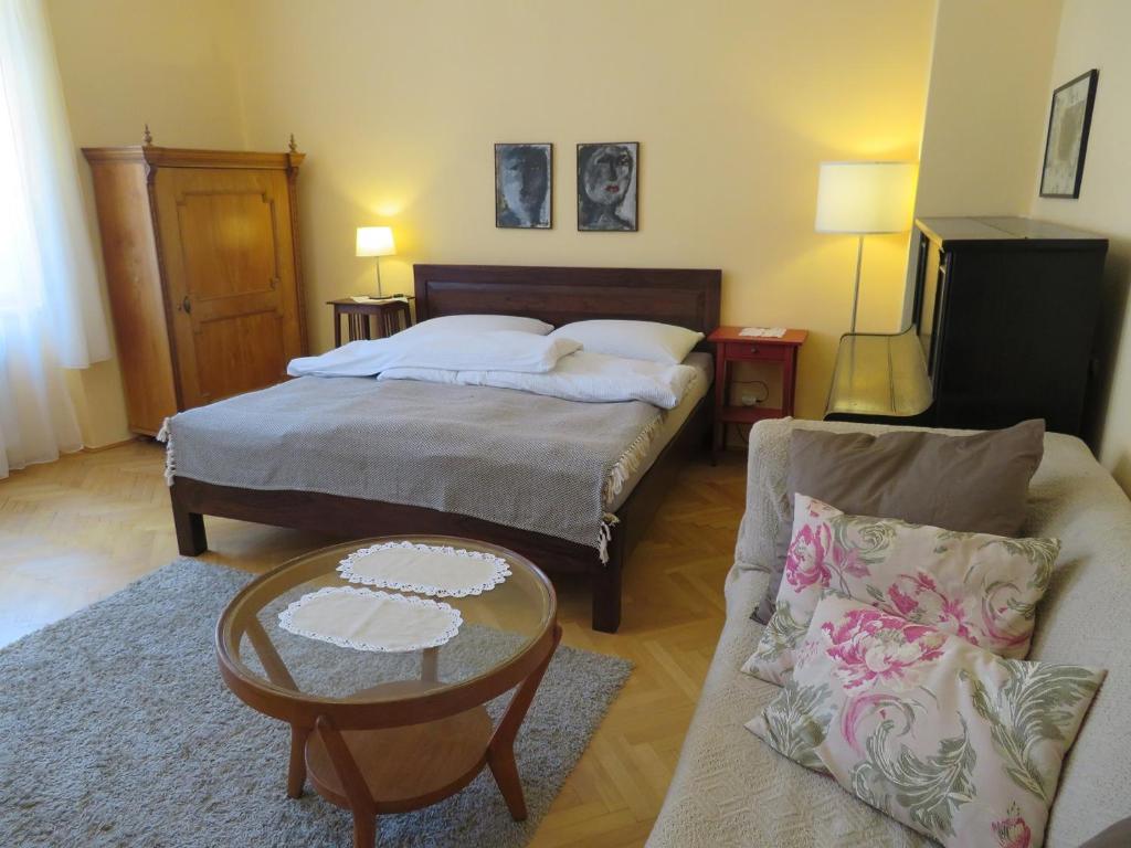 - une chambre avec un lit, une table et un canapé dans l'établissement Family Apartment Písek City Centre II., à Písek