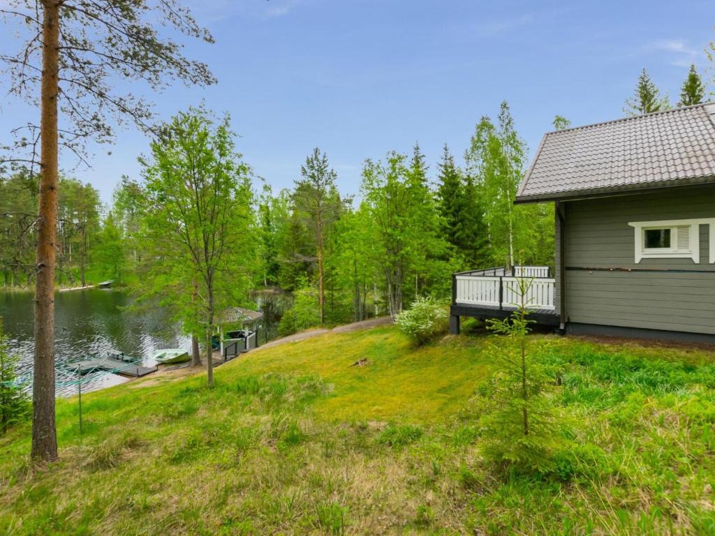 a house with a bench next to a body of water at Holiday Home Kiikkukallio by Interhome in Hankamäki