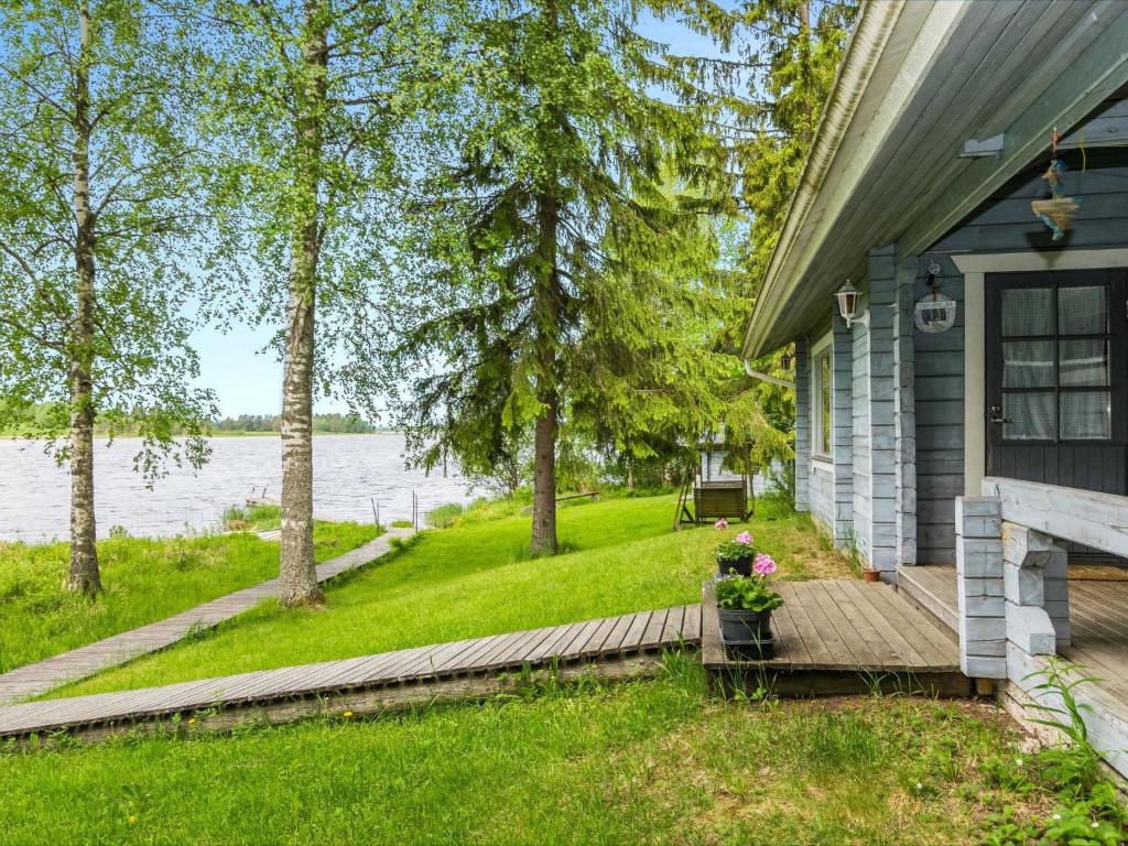 a house with a wooden deck next to a lake at Holiday Home Kuoppamäki by Interhome in Lapinlahti