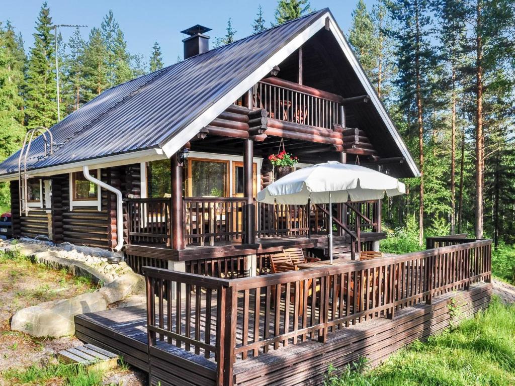 Kuusjärvi的住宿－維庫林偉蘭塔度假屋，小木屋设有门廊和雨伞