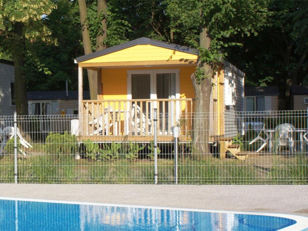 a small yellow house next to a swimming pool at Holiday Home Sunset Terrace by Interhome in Prague