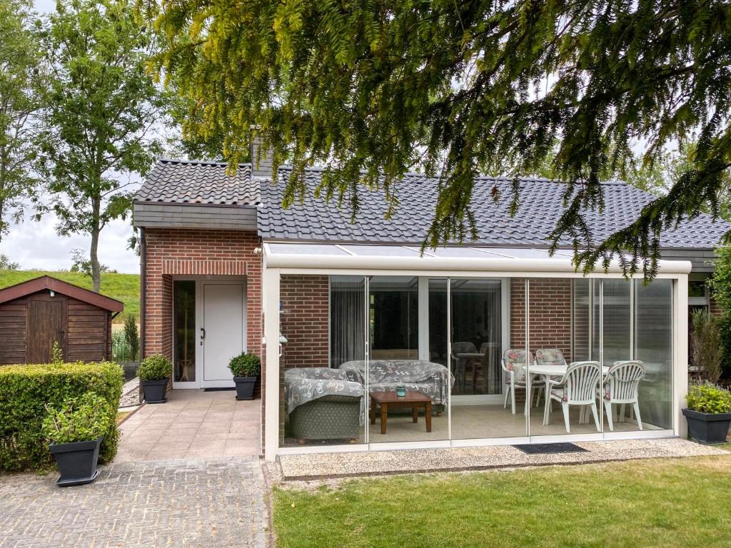 Casa con patio con mesa y sillas en Holiday Home Den Osse by Interhome en Brouwershaven