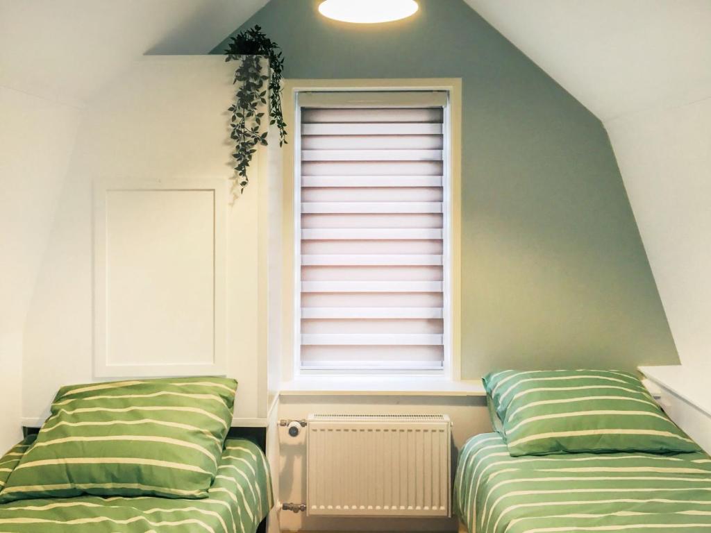 two beds in a room with a window at Holiday Home Brouwershaven by Interhome in Brouwershaven