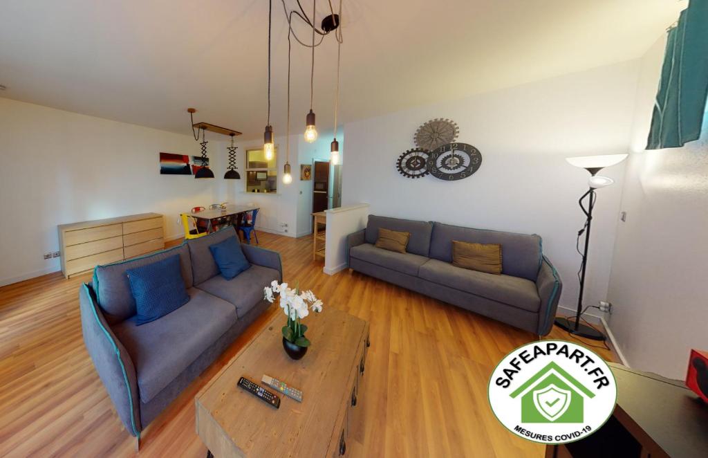 ein Wohnzimmer mit 2 Sofas und einem Couchtisch in der Unterkunft Le 23 - Strasbourg in Straßburg