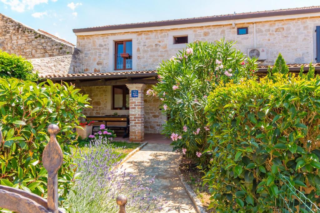 a stone house with a garden in front of it at Casa Ghedda in Gedići