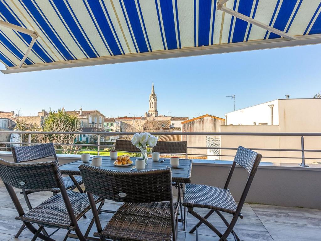 a table and chairs on a balcony with a view at Apartment La Closerie des Tremieres by Interhome in Saint-Georges-de-Didonne