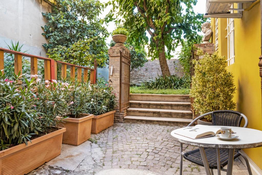 a patio with a table and some plants and stairs at Pratello Il Gelso Apartments in Bologna
