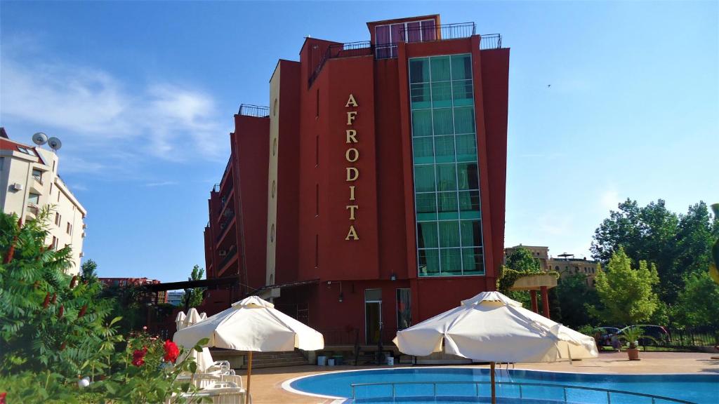 un hôtel avec deux parasols en face d'un bâtiment dans l'établissement Студио до Кики Бийч, à Sunny Beach