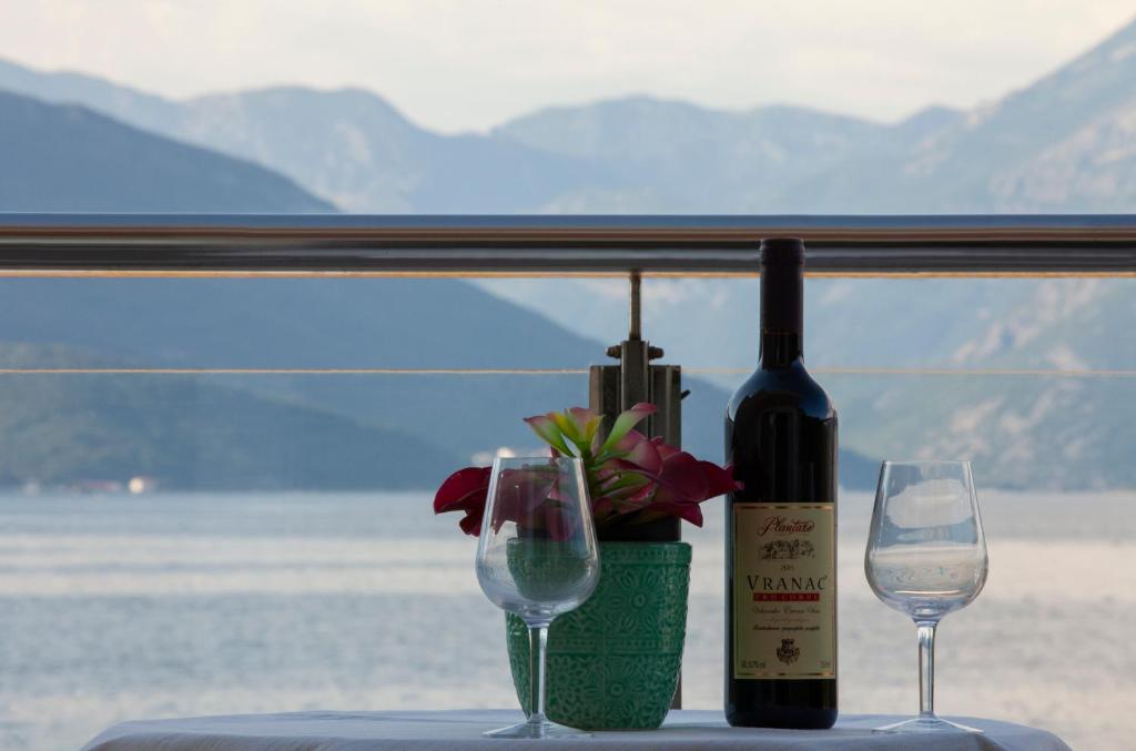 a bottle of wine and two glasses on a table at Leut Apartments in Tivat