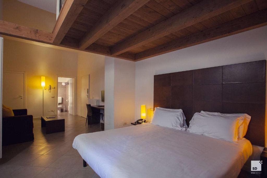 ein Schlafzimmer mit einem großen Bett und ein Wohnzimmer in der Unterkunft Appartamenti Resort Roma 6.3 e Resort I Banchieri in Ravenna