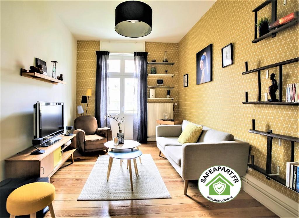 - un salon avec un canapé et une télévision dans l'établissement Le Leblois - 2 sdb Grande cuisine, à Strasbourg