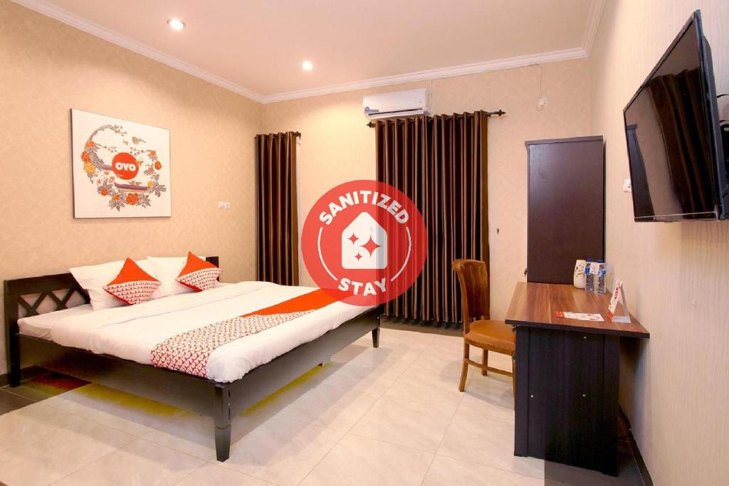 a bedroom with a bed with a sign on it at OYO 347 Bayang Brothers Guest House in Yogyakarta