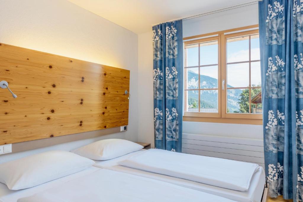 a bedroom with two beds and a window at Hapimag Ferienwohnungen Flims in Flims