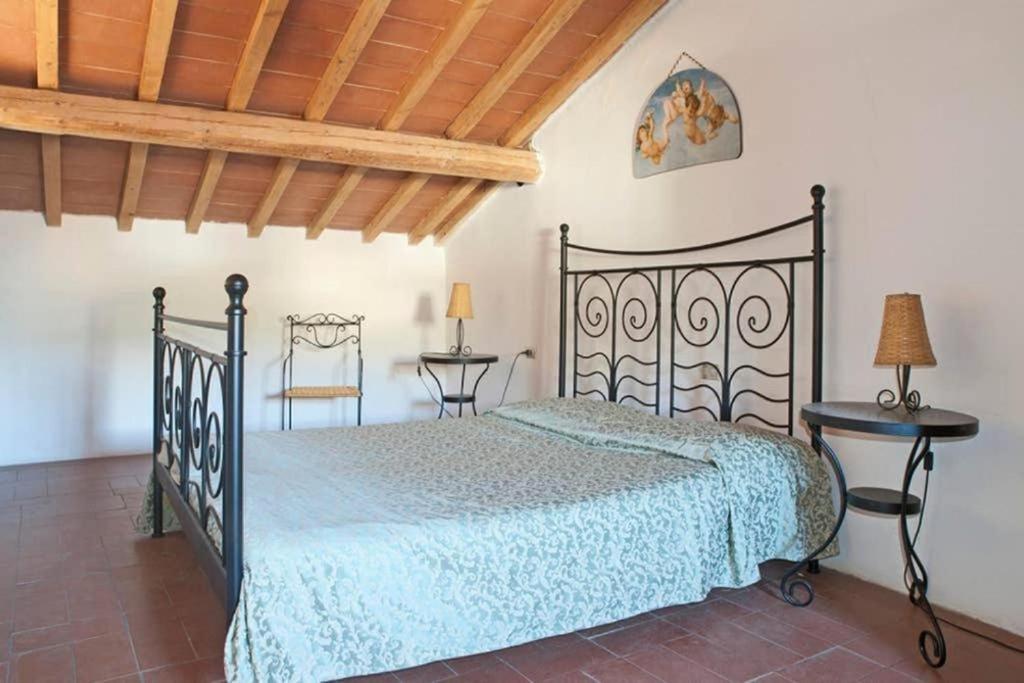 sypialnia z czarnym łóżkiem i dwoma stołami w obiekcie Happy Florence Matteotti Square Greve w Greve in Chianti