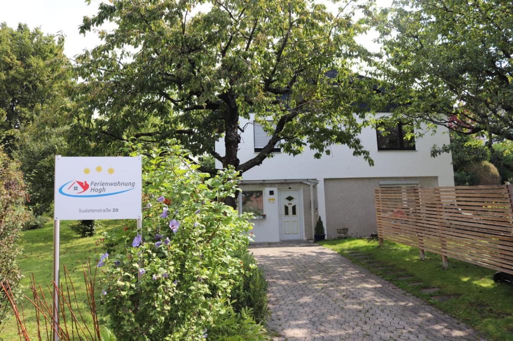 una casa blanca con un cartel delante en Ferienwohnung Hogh en Beuren