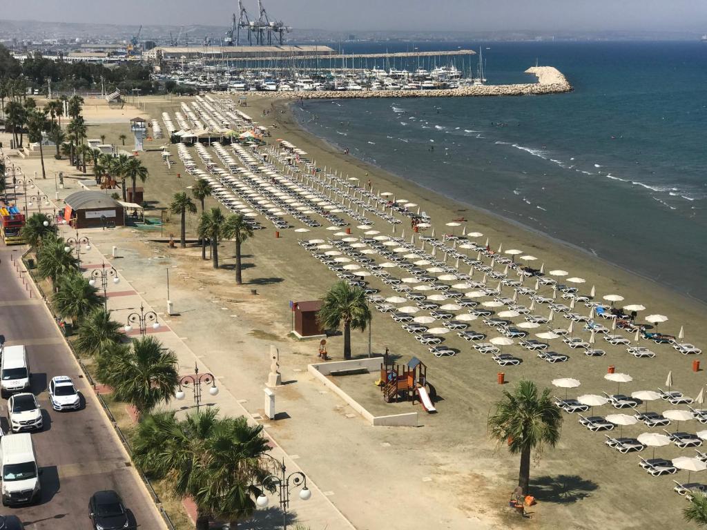 una vista aerea di una spiaggia con auto e ombrelloni di Panoramic Sea View Apartments a Larnaka