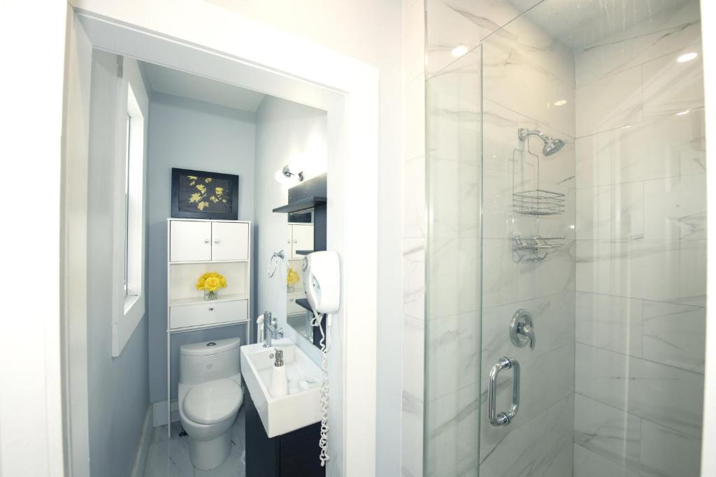 a bathroom with a toilet and a sink and a shower at Serene Niagara Inn in Niagara Falls