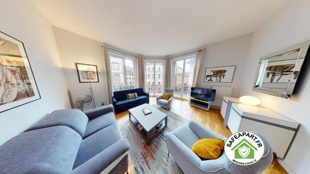 uma sala de estar com um sofá azul e uma mesa em Bleu Mésange - 2 Bedrooms and 2 Bathrooms em Estrasburgo