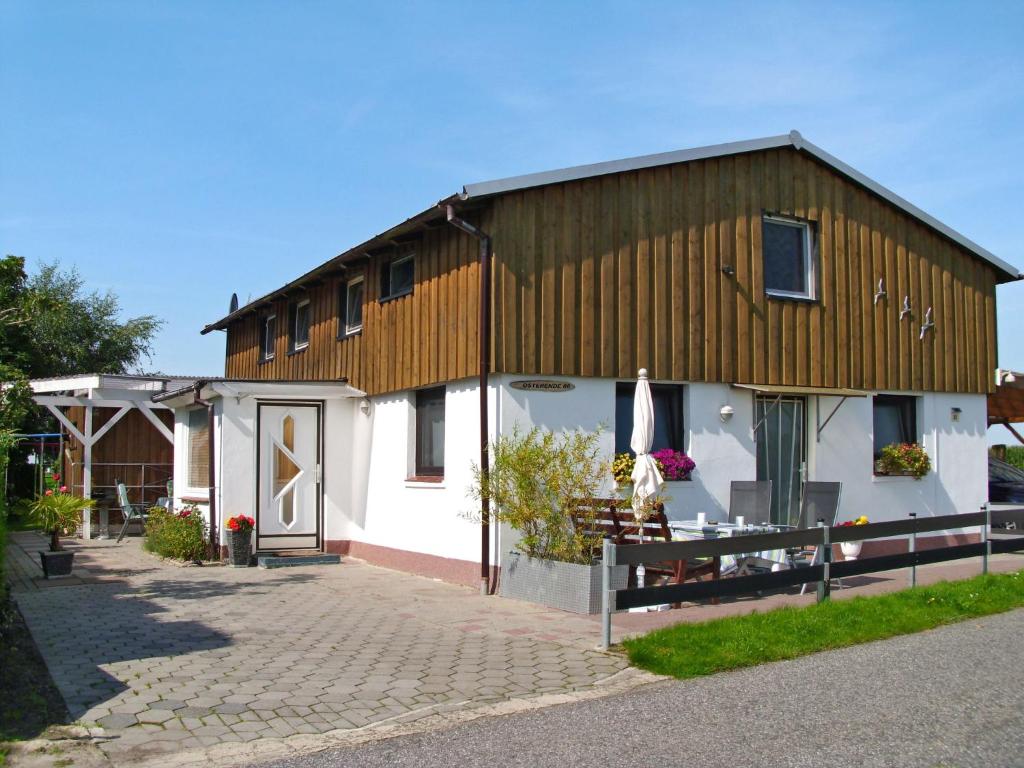 a large white building with a wooden roof at Apartment Osterende-1 by Interhome in Süderwisch