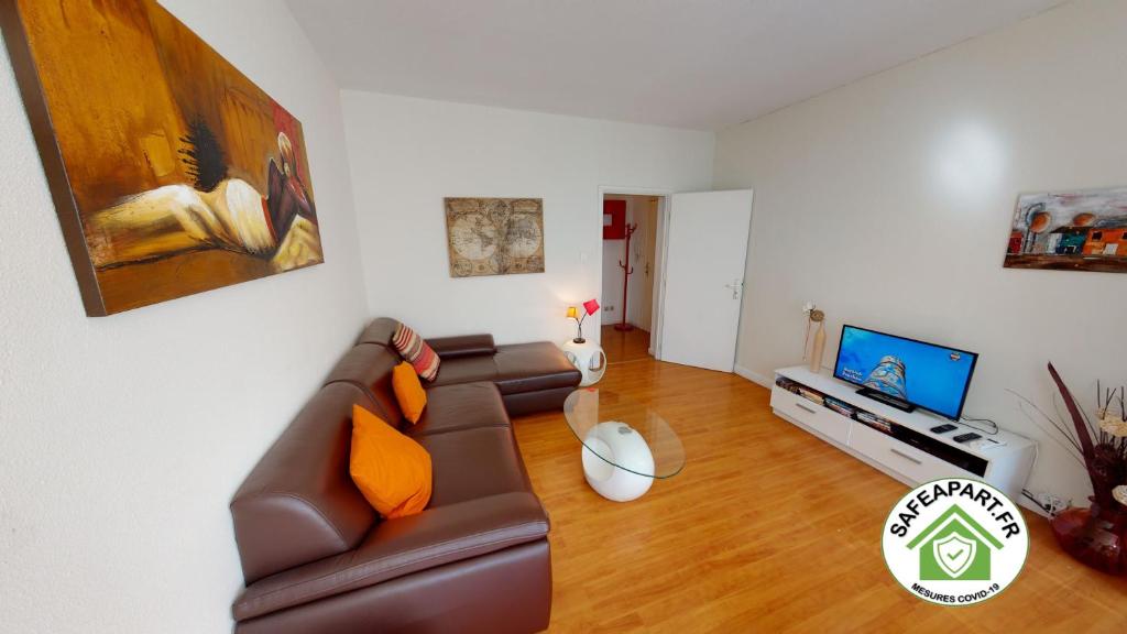 ein Wohnzimmer mit einem Sofa und einem TV in der Unterkunft Kleber - Les Halles in Straßburg