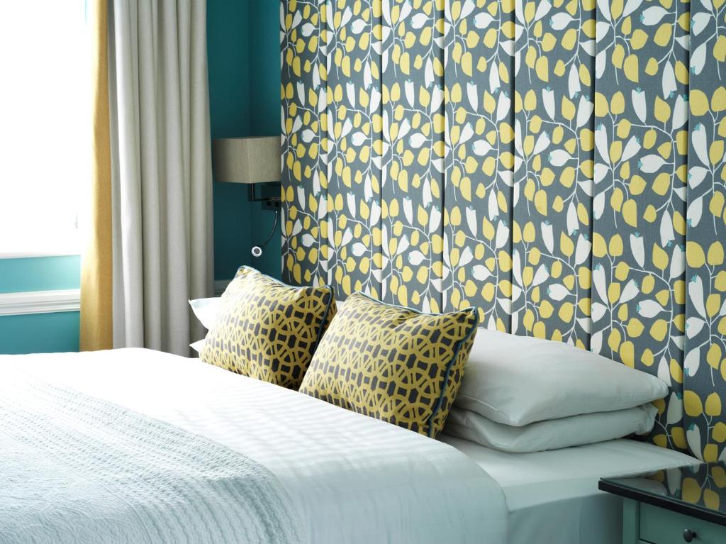 a bedroom with a bed with a blue and yellow wallpaper at Hayes Hotel in Thurles