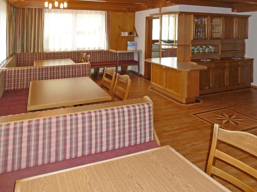 a living room with tables and chairs and a kitchen at Holiday Home Paznaun - KPL115 by Interhome in Kappl