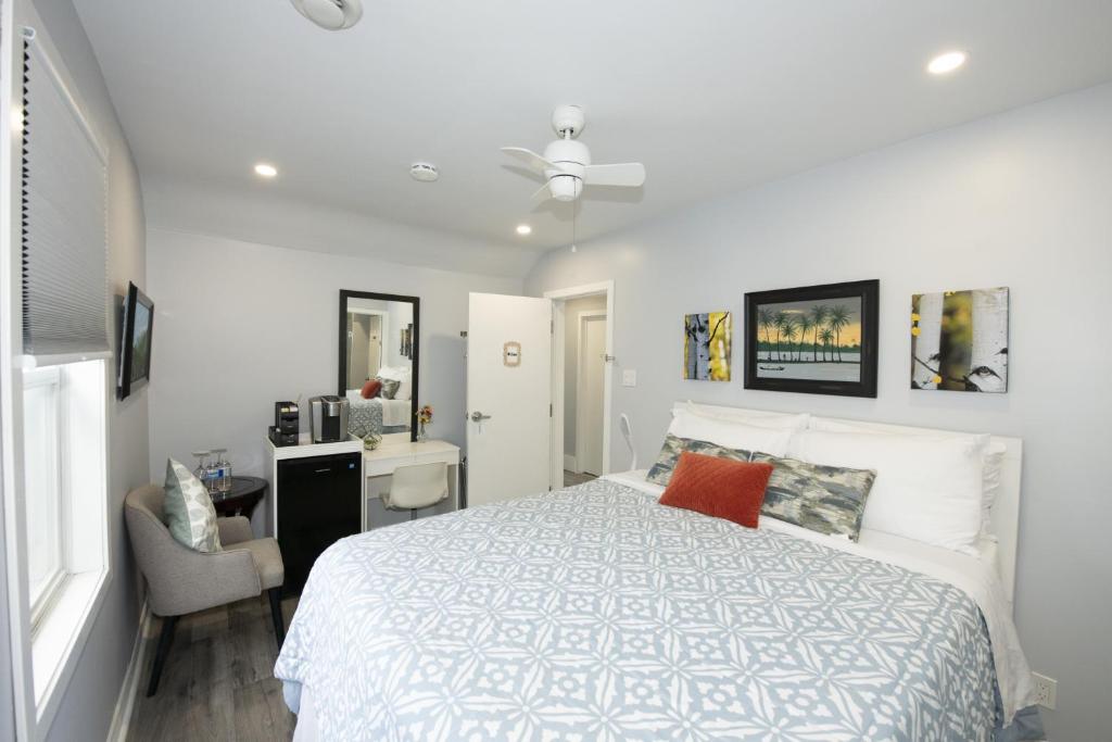 a bedroom with a white bed and a desk and a chair at Serene Niagara Inn in Niagara Falls