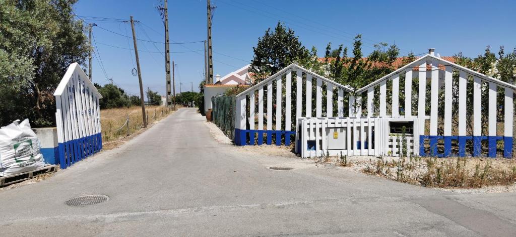 une clôture blanche et bleue sur le côté d'une route dans l'établissement Retiro dos Batudes, à Palmela