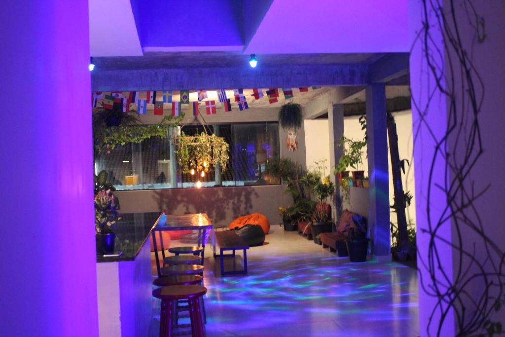 a room with a bar with purple lights on it at Massambaba Hostel in Arraial do Cabo